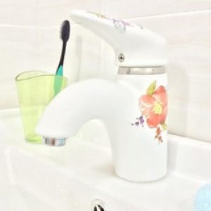 Robinet de lavabo en céramique orné d’une fleur rouge