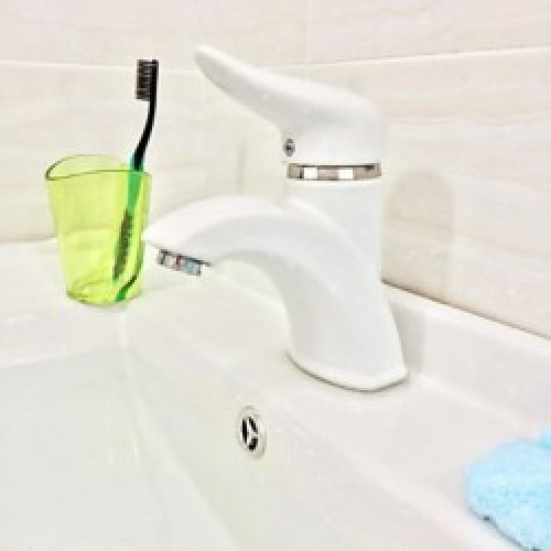 Robinet de lavabo blanc fait de céramique, un robinet à poignée unique avec un seul trou d’installation